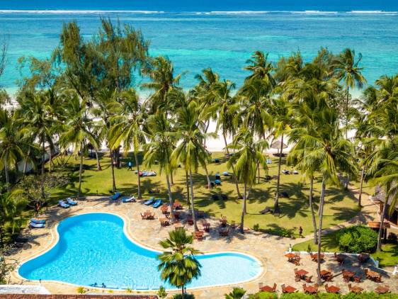 A picturesque beach with a swimming pool surrounded by lush palm trees, offering a tropical getaway.