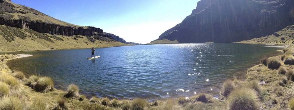 A serene water body on Mount Kenya, surrounded by rocky terrain and high-altitude landscape.