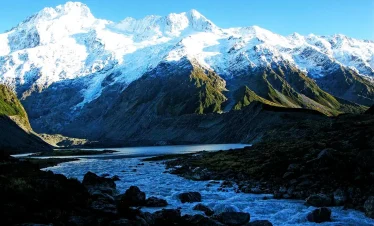 Snow-capped peaks of the Rwenzori Mountains, contrasting against a clear sky.