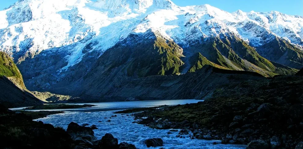 Snow-capped peaks of the Rwenzori Mountains, contrasting against a clear sky.