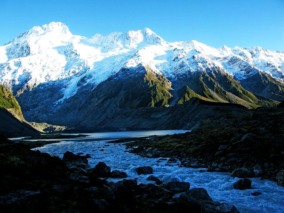 Snow-capped peaks of the Rwenzori Mountains, contrasting against a clear sky.